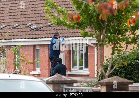 Macroom, West Cork, Irlanda. 8 Ott 2018. Un Garda cerca una grondaia di fronte alla casa della vittima dell'omicidio che è stata chiamata localmente come Timmy Foley 44 anni. Credit: Notizie dal vivo di AG/Alamy. Foto Stock