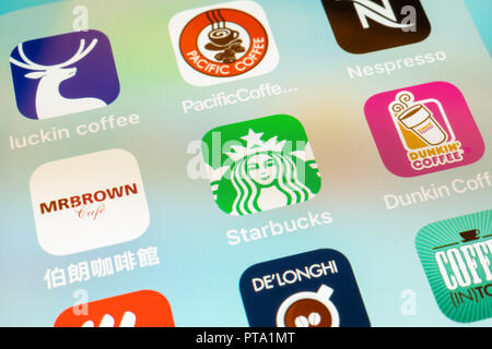 6 ottobre 2018, Wuhan, Cina : diversi caffè le icone delle app su un iphone schermo closeup con Starbucks Coffee logo in centro Foto Stock