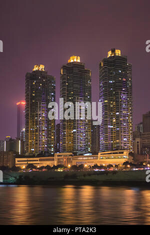 Illuminato e moderno appartamento edifici di notte nei pressi di un fiume di Chongqing Cina. Foto Stock