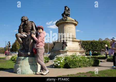 Per i visitatori stranieri che posano attorno al memoriale di Gower in Bancroft giardini. Le statue sono Shakespeariano e attirare attenzione da parte dei visitatori. Foto Stock