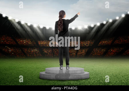 Vista posteriore di asian business donna in piedi sul podio a Stadium Foto Stock