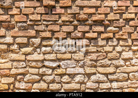 Foto orizzontale con texture. La trama mostra la parete di mattoni. La parete è vecchio e consumato. La parete è catturato a San Gimignano in Italia Toscana durante la s Foto Stock