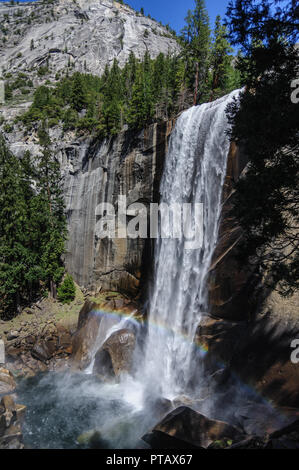 Un arcobaleno che mostra fino di fronte Vernall Fall, lungo il sentiero di nebbia, nel Parco Nazionale di Yosemite Foto Stock