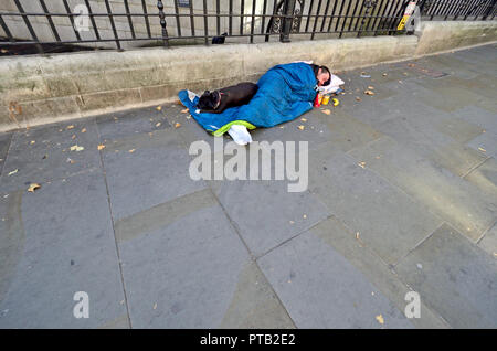 Senzatetto sonno agitato con il suo cane, la zona centrale di Londra, Inghilterra, Regno Unito. Foto Stock