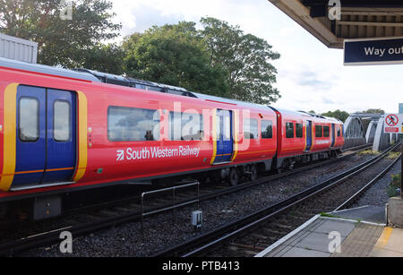 Treno delle Ferrovie del Sud Ovest che passa attraverso la stazione ferroviaria di Barnes Bridge Mortlake London UK Foto Stock