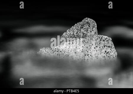 In bianco e nero, monocromatiche, astratta, notte di composizione di pietre in acqua. La nerezza e atmosfera di calma nel paesaggio roccioso. Foto Stock