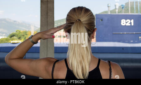 Tivat, Montenegro - Vista da dietro di una bella donna bionda saluto il sommergibile in pensione della marina militare jugoslava Foto Stock