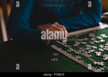 Senior donna giocando puzzle a casa Foto Stock