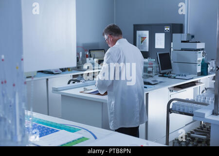 Scienziato maschio sperimentazione in laboratorio Foto Stock