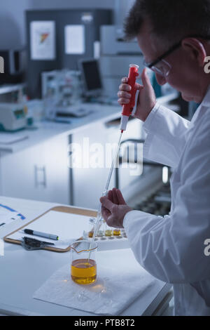 Scienziato maschio sperimentazione in laboratorio Foto Stock