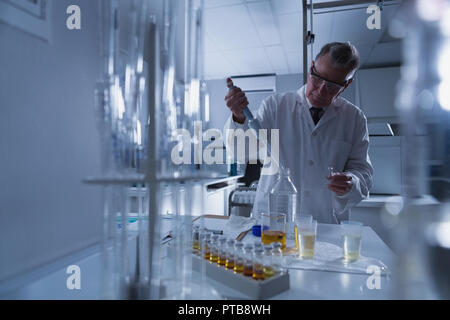 Scienziato maschio sperimentazione in laboratorio Foto Stock