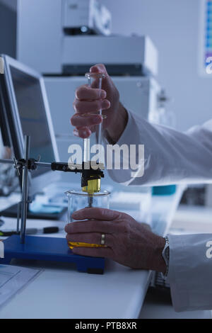 Scienziato maschio sperimentazione in laboratorio Foto Stock