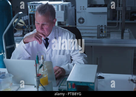 Scienziato maschio utilizzando laptop in laboratorio Foto Stock