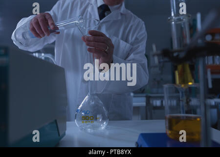 Scienziato maschio sperimentazione in laboratorio Foto Stock