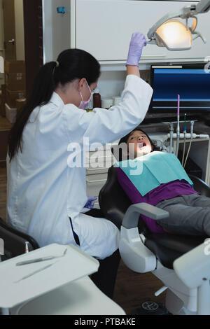 Dentista femmina e infermiere esame paziente Foto Stock