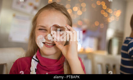 Ragazza che mostra una forma di cuore cookie cutter Foto Stock