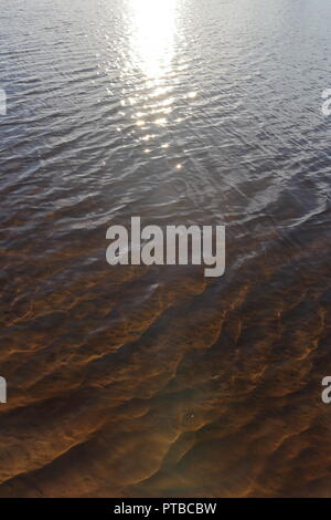 Un lago illuminato dal sole di setting che mostra subacquea dune di sabbia Foto Stock