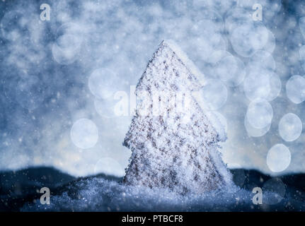 Albero di natale con la neve e il bokeh in luce blu Foto Stock