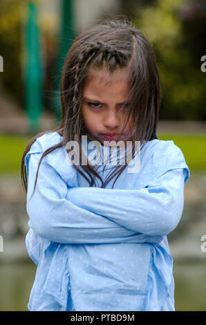 Arrabbiato bambina mostrando senso di frustrazione e di disaccordo in strada Foto Stock