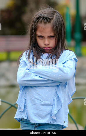 Arrabbiato bambina mostrando senso di frustrazione e di disaccordo in strada Foto Stock