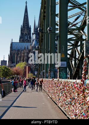 Il passaggio pedonale sul famoso Hohenzollern ponte ferroviario a Colonia ha migliaia di amore lucchetti attaccati alla recinzione Foto Stock