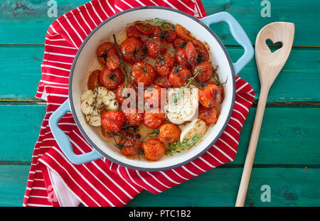 Tostatura di pomodori a grappolo con aglio e timo in una padella Foto Stock