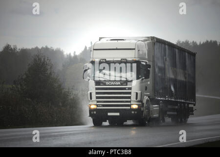 Salo, Finlandia - 28 Settembre 2018: Bianco Scania 114L semi rimorchio trasporta merci lungo la strada in cattive condizioni meteorologiche durante la pioggia. Foto Stock