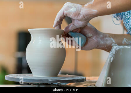 Creazione di un vaso o in un vaso di argilla bianca di close-up. Master coccio. Man mano rendendo brocca di argilla macro. Lo scultore in officina fa una brocca dall earthenw Foto Stock