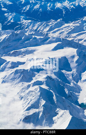 Antenna unica vista impressionante cumulus temporale corpi nuvole su strade coperte di neve a sud Europa centrale regione montana visto attraverso un aereo wi Foto Stock