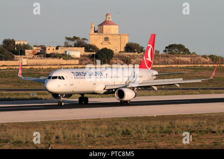 La Turkish Airlines Airbus A321 aviogetti aereo sulla pista al momento dello sbarco a Malta al tramonto. Il viaggio in aereo e il turismo in Europa mediterranea. Foto Stock