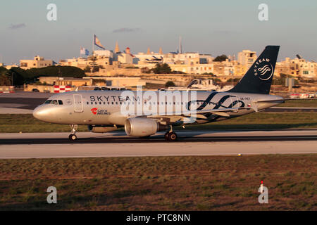 CSA Czech Airlines Airbus A319 jet del passeggero aereo nei colori dell'alleanza di compagnie aeree Skyteam decollare da Malta al tramonto. Voli intracomunitari. Foto Stock