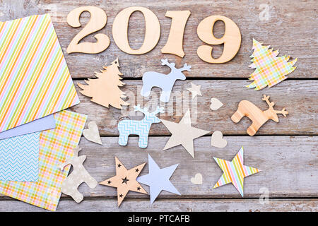 Testo in legno 2019 e nuovo anno cifre della carta. Anno nuovo design fatti a mano sul vecchio stile vintage sfondo di legno. Anno Nuovo 2019 carta tagliato le decorazioni Foto Stock