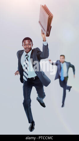 Felice afroamerican uomo correre con una valigetta in mano. in background- il suo collega cercando di catturare fino a lui. Foto Stock