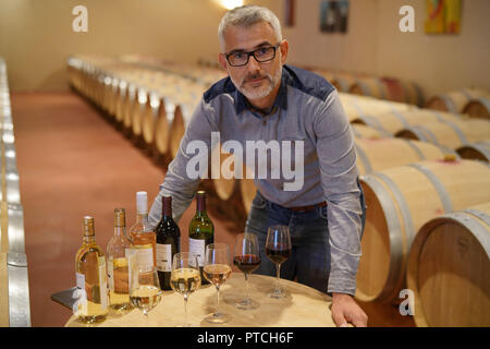 Uomo in piedi in cantina intorno al tavolo Foto Stock