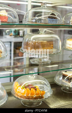 Dolci e Torte in vetrina nella pasticceria. Coperchio in vetro Foto Stock