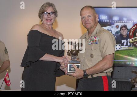 Il comandante del Marine Corps gen. Robert B. Neller, destra stringe la mano ad Ilaria San Giovanni, nipote di Clifford battaglie, DURANTE GLI STATI UNITI Marine Corps Sports Hall of Fame cerimonia di investitura presso il Museo Nazionale del Marine Corps, Triangolo, Virginia, luglio 12, 2017. Battaglie entrato a far parte della National Football League nel 1931 e ha giocato per la Boston Braves fino al 1937 e servito come una preparazione atletica e ricreazione Officer negli Stati Uniti Marine Corps dal 1943 al 1952. Foto Stock