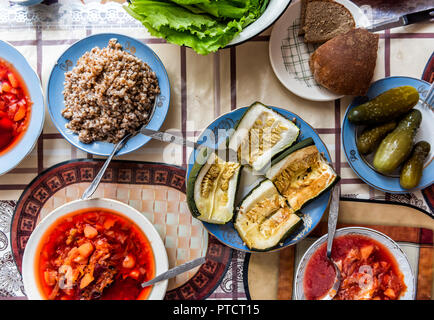 Sommità piana, ad alto angolo di visione verso il basso della tabella con l'impostazione di un sano vegetariano vegano il pranzo o la cena, verdure, insalata di cetrioli sottaceto sottaceti, Foto Stock