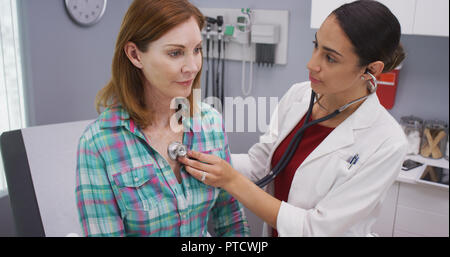 Close up senior tenendo il paziente respiri mentre il giovane medico utilizza uno stetoscopio Foto Stock