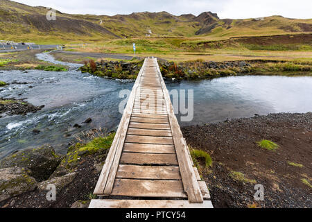 Hveragerdi Hot Springs trail nel Reykjadalur, durante la stagione autunnale mattinata estiva giorno nel sud dell'Islanda, Golden Circle, rocce e ponte di legno Varcando il fiume Foto Stock