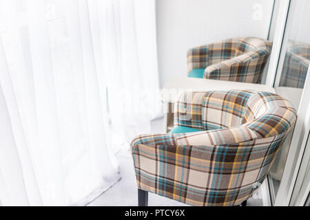 Sedie, Poltrone e pianta verde nella nuova casa closeup con semplici, minimalismo sul balcone coperto nel modello di staging di casa o appartamento, tende bianche b Foto Stock