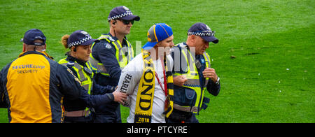 Arresto della polizia e scortando un invasore passo al 2018 AFL Grand Final di MCG Melbourne Victoria Australia. Foto Stock