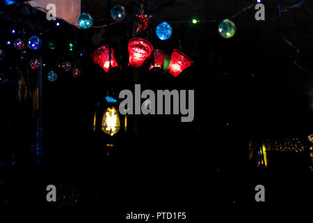 Colori luminosi lampadine luce visibile attraverso una finestra di vendita al dettaglio di notte Foto Stock