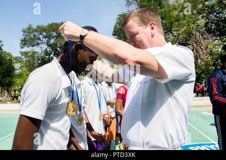 CHENNAI, India (11 luglio 2017) Capt. Kevin Lenox, comandante della portaerei USS Nimitz CVN (68), pone una medaglia sopra la testa di uno studente dalla YMCA College di educazione fisica a Chennai, in India dopo una comunità progetto Relazioni tra gioco di basket durante il Malabar 2017. Il Malabar 2017 è il più recente di una serie continua di esercizi tra la Marina indiana, Japan Maritime Self Defence Force e U.S. La marina che è cresciuta in termini di portata e complessità nel corso degli anni per affrontare la varietà condiviso di minacce alla sicurezza marittima nell'Indo-Asia-regione del Pacifico. Foto Stock