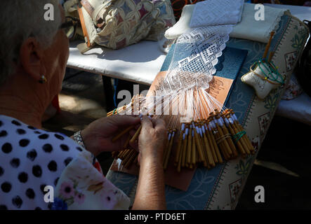 Il merletto a tombolo weaver donna mostrando il suo tradizionale tecnica artigianale durante una fiera locale nel villaggio di Esporles nell'isola spagnola di Maiorca. Foto Stock