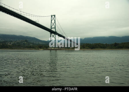 Sotto i cieli nuvolosi e grigi, il Lions Gate Bridge si estende da Burrard Inlet dallo Stanley Park di Vancouver a North Vancouver, British Columbia, Canada Foto Stock