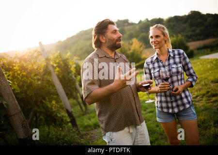 I viticoltori che mostra le uve e parlando in vigna Foto Stock