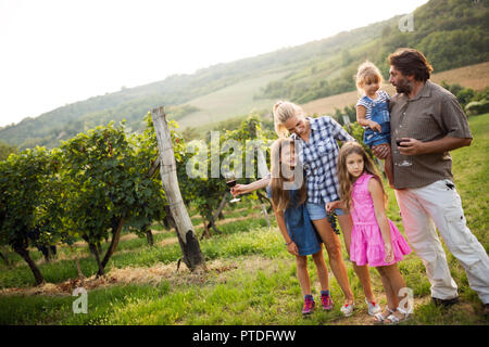 Felice viticoltore famiglia passeggiate in vigna Foto Stock