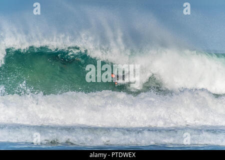 St Ives, Cornwall, Regno Unito. Il 9 ottobre 2018. Regno Unito Meteo. Surfers rendendo la maggior parte del wam e condizioni ventose sulla spiaggia di St Ives questo pomeriggio. Credito: Simon Maycock/Alamy Live News Foto Stock