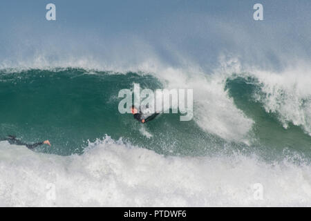 St Ives, Cornwall, Regno Unito. Il 9 ottobre 2018. Regno Unito Meteo. Surfers rendendo la maggior parte del wam e condizioni ventose sulla spiaggia di St Ives questo pomeriggio. Credito: Simon Maycock/Alamy Live News Foto Stock