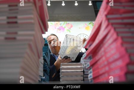 Francoforte, Germania. 09 ottobre 2018, Assia, Frankfurt principale: Michael Zirn da Frechverlag Stuttgart è occupato con preparati all'editore stand alla fiera del libro di Francoforte. Il più grande del mondo mostra del libro si svolge dal 10 al 14 Ottobre. Foto: Arne Dedert/dpa Credito: dpa picture alliance/Alamy Live News Foto Stock